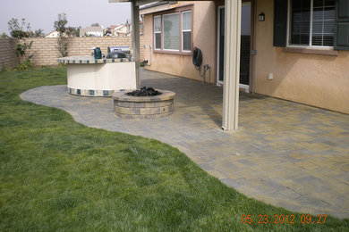 Photo of a mid-sized traditional backyard concrete paver landscaping in Los Angeles with a fire pit.