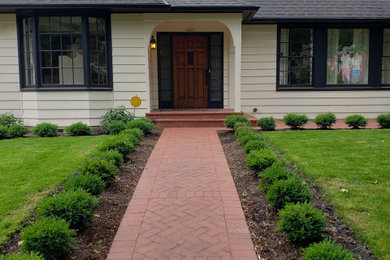 Inspiration for a mid-sized traditional full sun front yard brick landscaping in Portland for winter.