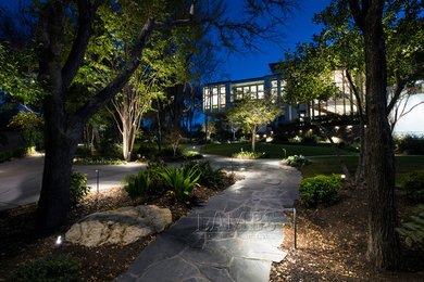 This is an example of a contemporary partial sun backyard stone landscaping in Dallas.