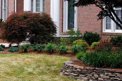 This is an example of a large traditional full sun front yard retaining wall landscape in Baltimore.