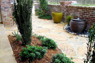 Photo of a large traditional partial sun front yard stone garden path in New Orleans.