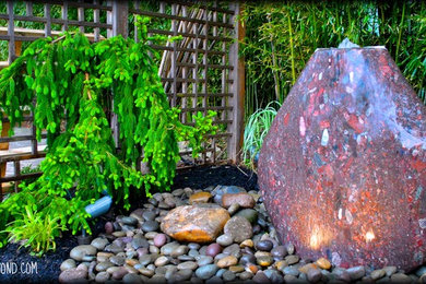 Photo of a mid-sized contemporary partial sun backyard gravel landscaping in New York.