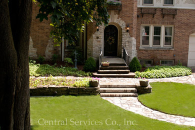 This is an example of a mid-sized traditional shade front yard stone garden path in Milwaukee.