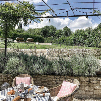 Design ideas for a french country backyard gravel retaining wall landscape in Los Angeles.