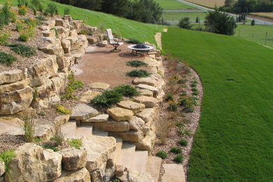 Imagen de jardín rural grande en patio trasero con muro de contención, exposición total al sol y adoquines de piedra natural
