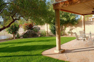 This is an example of a mid-sized traditional partial sun backyard stone driveway in Phoenix.