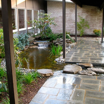 Front entrance pond and stream breaking through the walkway