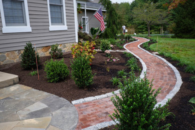 This is an example of a mid-sized traditional front yard brick landscaping in Philadelphia.