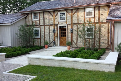 Modelo de jardín rústico de tamaño medio en patio delantero con adoquines de piedra natural