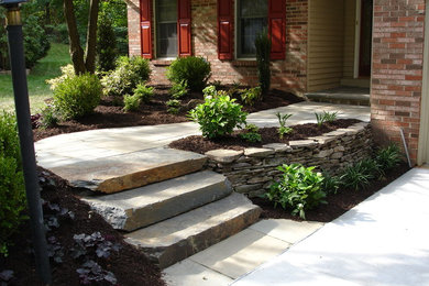 Inspiration for a mid-sized traditional partial sun front yard stone retaining wall landscape in Baltimore.