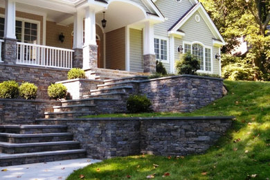 This is an example of a mid-sized traditional partial sun front yard concrete paver landscaping in New York.