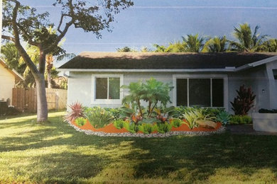Imagen de jardín tropical de tamaño medio en patio delantero con jardín francés y exposición parcial al sol