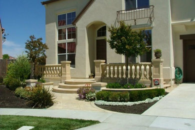 This is an example of a large classic front driveway full sun garden in San Francisco with a garden path and concrete paving.
