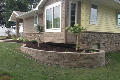 This is an example of a traditional front yard brick retaining wall landscape in Other.