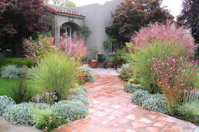 Idee per un giardino eclettico esposto in pieno sole davanti casa in primavera con un ingresso o sentiero