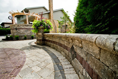 Design ideas for a mid-sized traditional full sun backyard concrete paver retaining wall landscape in Toronto for summer.