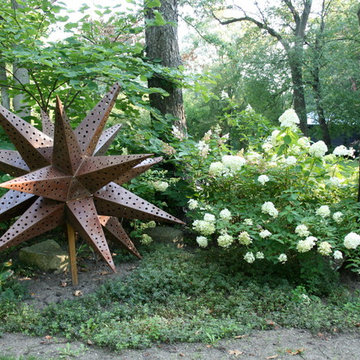 Further into the deep lot hydrangea mingles with a large rusty star.