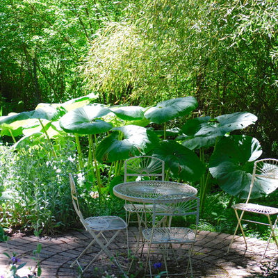 Photo of a mid-sized eclectic shade backyard brick formal garden in Seattle for summer.