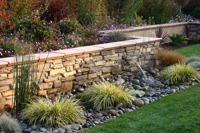 This is an example of a large traditional backyard water fountain landscape in New York.