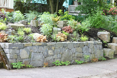 Foto de jardín de tamaño medio en patio trasero con muro de contención, exposición total al sol y adoquines de piedra natural