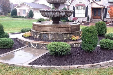 This is an example of a large full sun front yard stone water fountain landscape in Charlotte.