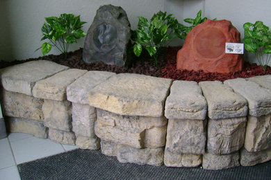 Modelo de jardín tradicional grande en patio delantero con muro de contención