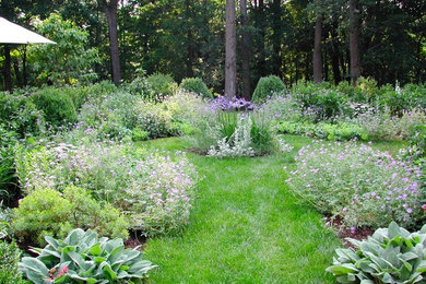 На фото: солнечный, весенний регулярный сад среднего размера на заднем дворе в классическом стиле с хорошей освещенностью и садовой дорожкой или калиткой