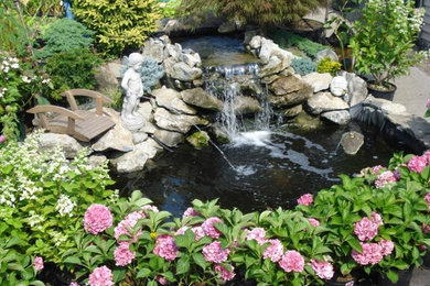 Idee per un grande giardino in cortile con fontane e pavimentazioni in pietra naturale