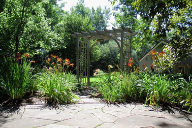 Cette image montre un aménagement d'entrée ou allée de jardin arrière traditionnel de taille moyenne avec une exposition partiellement ombragée et des pavés en pierre naturelle.