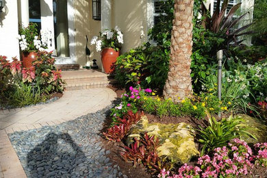Immagine di un giardino formale tradizionale esposto in pieno sole di medie dimensioni e davanti casa in estate con un ingresso o sentiero e pavimentazioni in mattoni