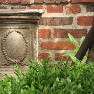 Garden pedestal detail with traditional plantings for shade