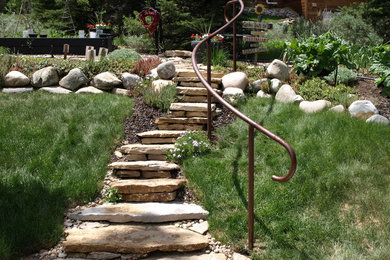 This is an example of a mid-sized rustic shade backyard stone landscaping in Denver.