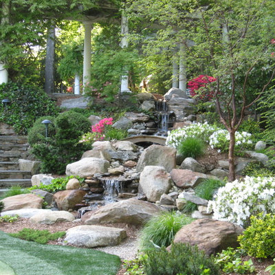 This is an example of a large traditional partial sun backyard stone waterfall in Miami for spring.