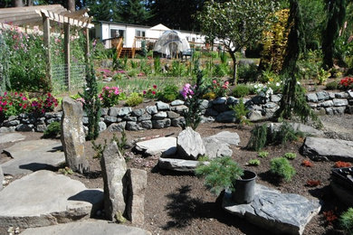 Imagen de jardín tradicional renovado grande con jardín francés, muro de contención, mantillo y exposición total al sol