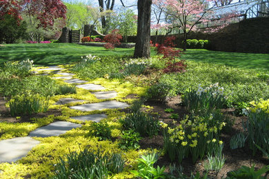 Cette image montre un grand aménagement d'entrée ou allée de jardin arrière traditionnel au printemps avec des pavés en béton et une exposition partiellement ombragée.