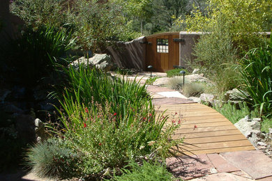 Imagen de jardín en patio delantero con fuente y adoquines de piedra natural
