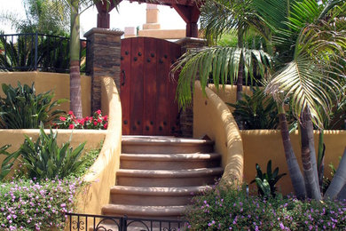 Large world-inspired back full sun garden in San Diego with a garden path and natural stone paving.