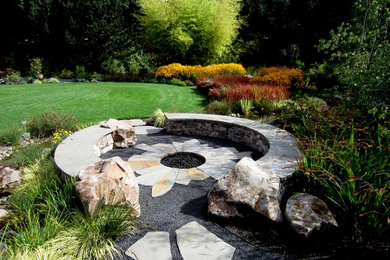 This is an example of a medium sized contemporary back full sun garden for summer in Portland with a fire feature and natural stone paving.