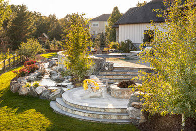 Inspiration for a large french country full sun backyard concrete paver landscaping in Denver with a fire pit.