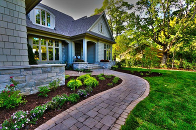 Photo of a mid-sized traditional shade front yard stone driveway in Minneapolis.