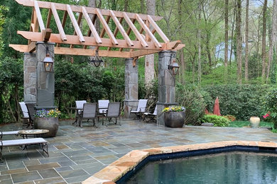 Modelo de piscina tradicional rectangular en patio trasero con adoquines de piedra natural