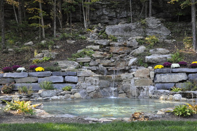 Inspiration for a huge transitional partial sun backyard stone landscaping in New York.