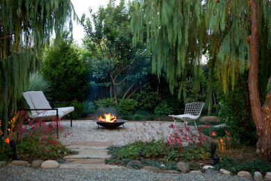 Ejemplo de jardín contemporáneo pequeño en patio trasero con brasero y adoquines de piedra natural