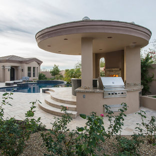 Großer Mediterraner Garten hinter dem Haus mit Kamin und Natursteinplatten in Phoenix