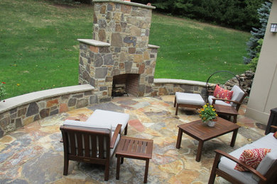 Inspiration for a large classic back patio in New York with a fire feature and natural stone paving.