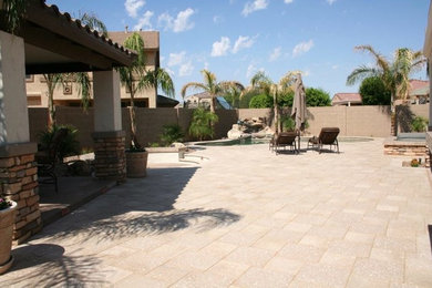 フェニックスにある高級な広いトロピカルスタイルのおしゃれな裏庭のテラス (ファイヤーピット、天然石敷き) の写真