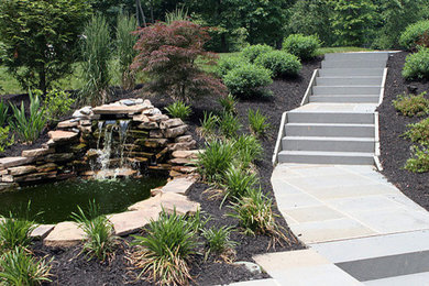 This is an example of a classic back garden in Philadelphia with a water feature and natural stone paving.