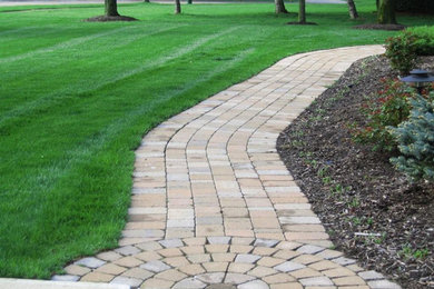 Photo of a mid-sized partial sun front yard concrete paver garden path in Cleveland.
