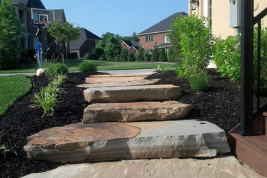 Imagen de acceso privado de tamaño medio en patio delantero con exposición total al sol y adoquines de piedra natural