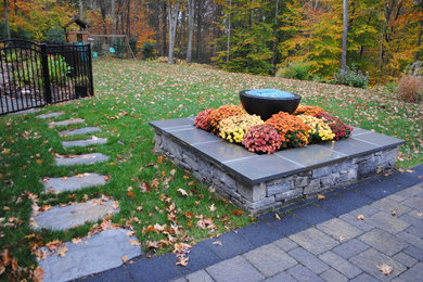 Inspiration for a traditional backyard stone landscaping in Bridgeport with a fire pit.